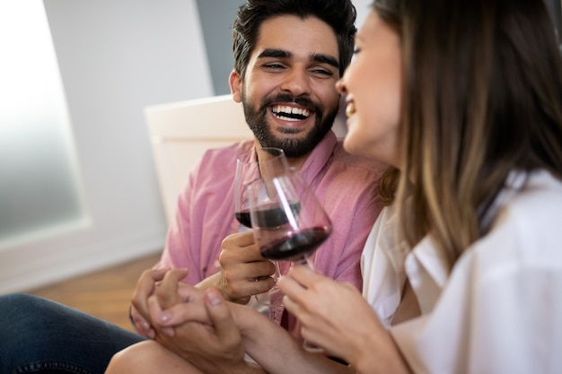 Foto hermosa pareja está sonriendo, hablando y abrazándose mientras pasan tiempo juntos en el dormitorio