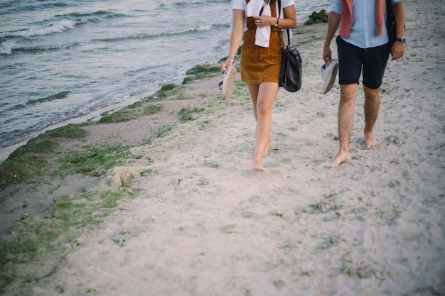 Hermosa pareja tomados de la mano y paseos a la orilla del mar