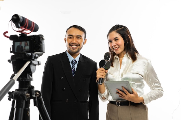 Foto una hermosa periodista con blusa blanca hablando con la cámara usando un micrófono mientras entrevista