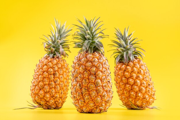 Hermosa piña fresca aislada sobre fondo amarillo brillante, concepto de patrón de idea de diseño de fruta de temporada de verano, espacio de copia, de cerca