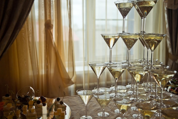 Foto hermosa pirámide de copas de champán en el fondo de una victoria ligera