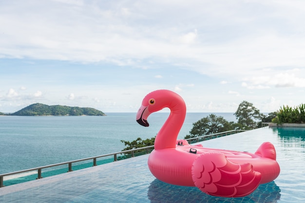 Hermosa piscina al aire libre en el hotel resort con flamingo flotar alrededor del mar océano nube blanca sobre cielo azul para el concepto de viaje de vacaciones de vacaciones