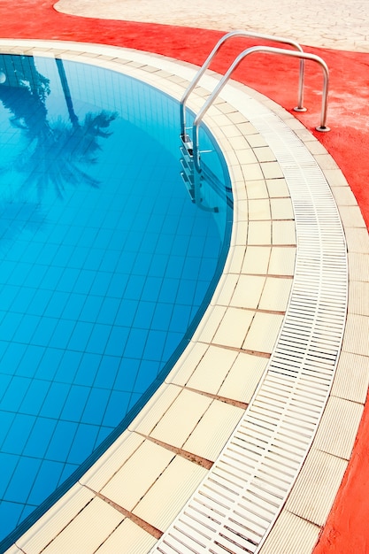 Hermosa piscina con pasos cerca del mar en el fondo de la naturaleza