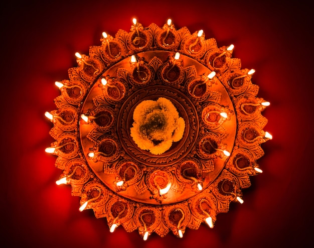 Hermosa placa diya diwali de terracota iluminada en la noche, iluminación cambiante, enfoque selectivo