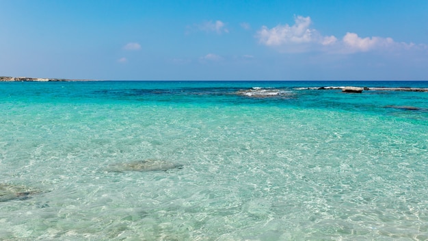 Hermosa playa con aguas cristalinas contra el cielo azul