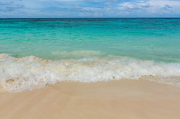 Hermosa playa de arena blanca y fondo de onda de mar azul