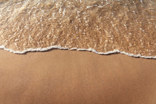 Hermosa playa de arena y olas de agua en la arena