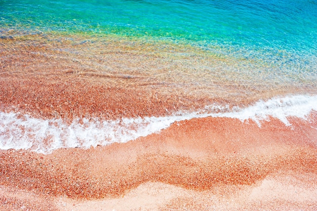 Hermosa playa de arena roja y agua turquesa. Mar Adriático, Montenegro. Fondo de viajes de verano, vista superior