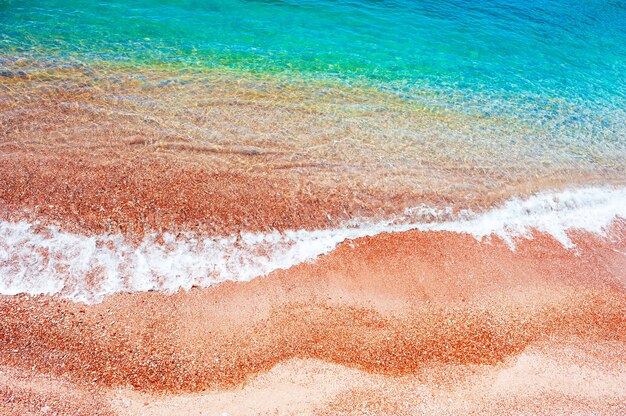 Hermosa playa de arena roja y agua turquesa. Mar Adriático, Montenegro. Fondo de viajes de verano, vista superior