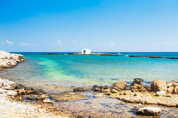 Hermosa playa y capilla blanca en el mar en Georgioupolis, isla de Creta, Grecia