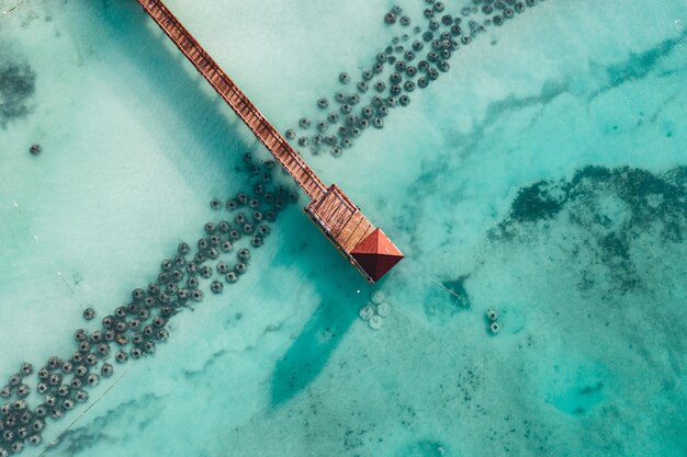 Hermosa playa caribeña en República Dominicana Vista aérea abstracta del idílico paisaje tropical de verano con agua de mar azul transparente y muelle rojo de madera