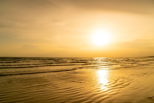 Hermosa playa de mar con puesta de sol