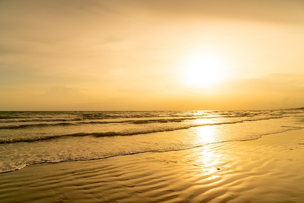 Hermosa playa de mar con puesta de sol