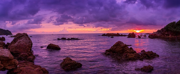 Hermosa playa de mar rocoso al atardecer