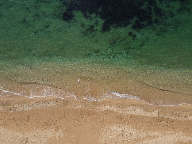 Foto hermosa playa remota con agua azul cristalina vista aérea naturaleza virgen y arena escondida