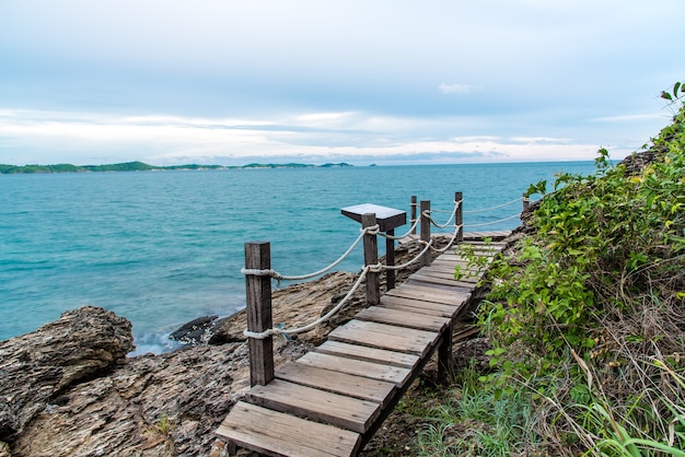 Foto hermosa playa de roca con el puente de madera