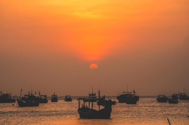 Hermosa playa tropical al atardecer con bote pequeño y cielo cinematográfico para viajes y vacaciones en vacaciones