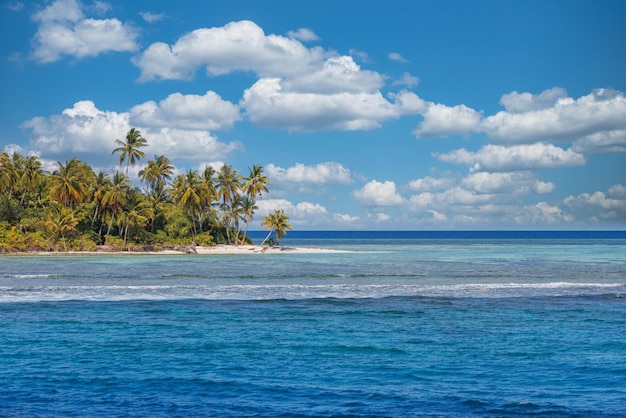 Hermosa playa tropical con arena blanca, palmeras, mar turquesa contra el cielo azul con nubes