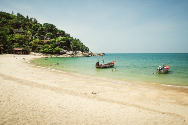 Hermosa playa tropical con barcos en aguas tranquilas azules. Tailandia, Koh Phangan, Haad Salad Beach