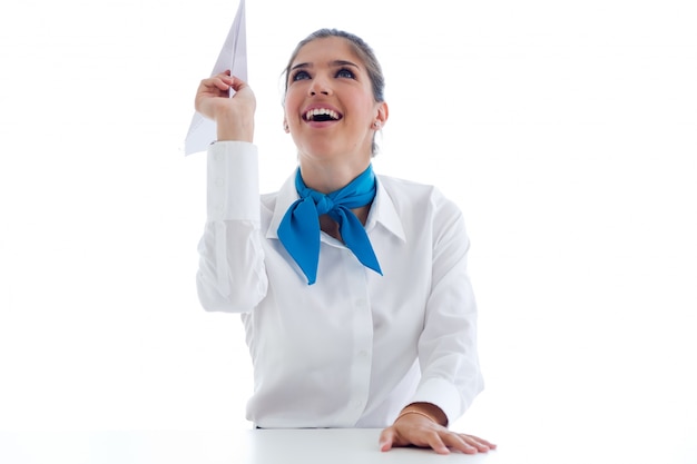 Hermosa presentadora sosteniendo el avión de papel. Aislado en blanco