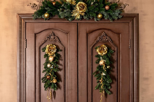 Hermosa puerta navideña con un árbol de Navidad y bolas doradas. Interior de la casa de Navidad