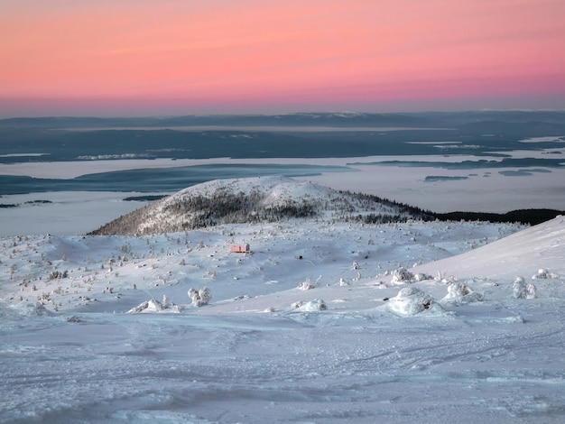 Hermosa puesta de sol ártica Cielo colorido escénico al amanecer Cabaña en invierno Dubldom en la montaña Volosyanaya Kandalaksha Región de Murmansk en Rusia