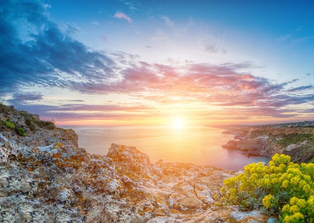 Hermosa puesta de sol colorida sobre el mar azul con nubes dramáticas vista panorámica mundo de belleza