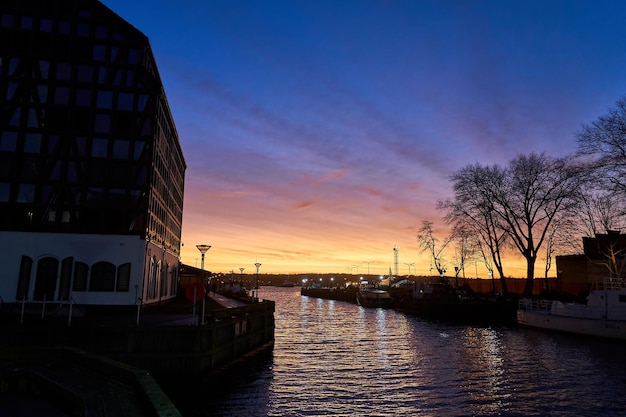 Foto una hermosa puesta de sol escarlata cerca del canal en klaipeda, lituania