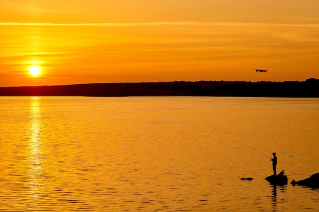 Hermosa puesta de sol en un lago. Paisaje de noche amarilla al aire libre.