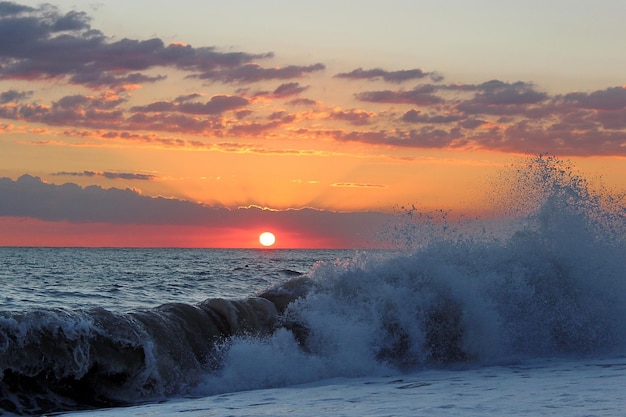 Hermosa puesta de sol en el mar. Olas y orilla.