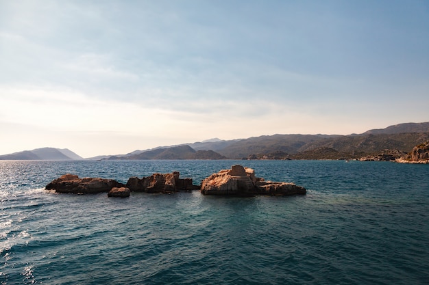 Hermosa puesta de sol en el mar con vistas a las montañas.