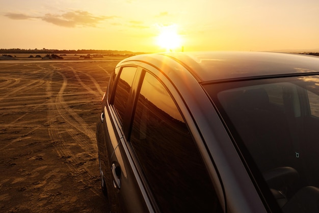 Foto hermosa puesta de sol y moderno automóvil todoterreno cerca de la playa
