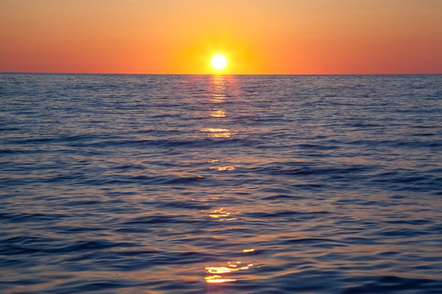 Hermosa puesta de sol naranja con azul mar rugiente