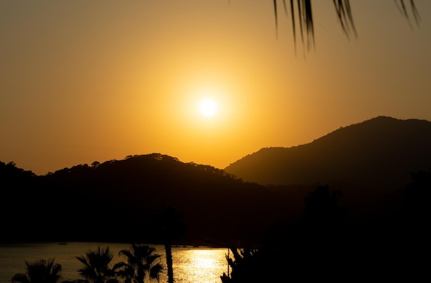 Hermosa puesta de sol entre palmeras y montañas en Oludeniz Turquía