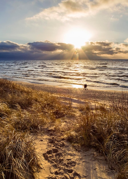 Hermosa puesta de sol en la playa de arena y dunas del Mar Báltico en Lituania Klaipeda