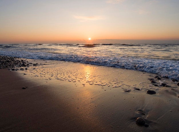 Hermosa puesta de sol en la playa de arena del Mar Báltico en Lietva Klaipeda