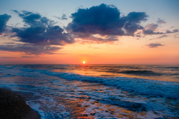 Hermosa puesta de sol en una playa de arena vacía.