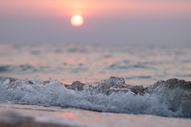 Hermosa puesta de sol en una playa. Olas del atardecer y el mar de verano.