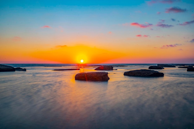 hermosa puesta de sol en la playa rocosa