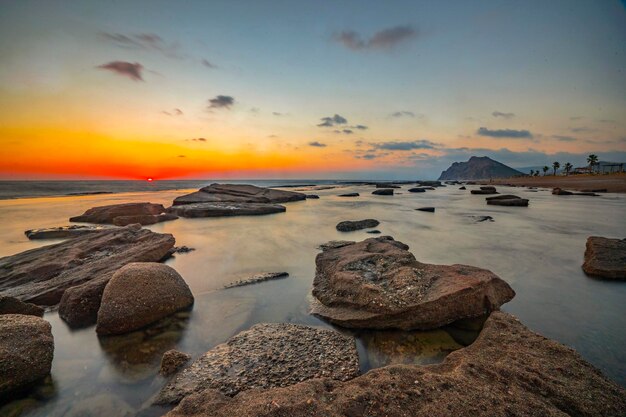 hermosa puesta de sol en la playa rocosa