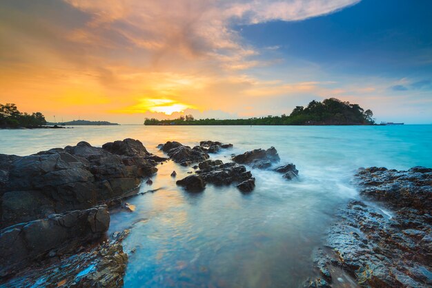 hermosa puesta de sol con rocas a lo largo de la playa