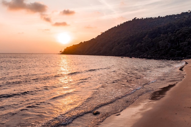 Hermosa puesta de sol con la silueta de una isla y un barco en Otres Camboya