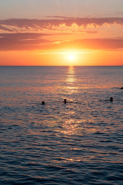 Hermosa puesta de sol sobre el mar y hermoso paisaje nublado foto vertical