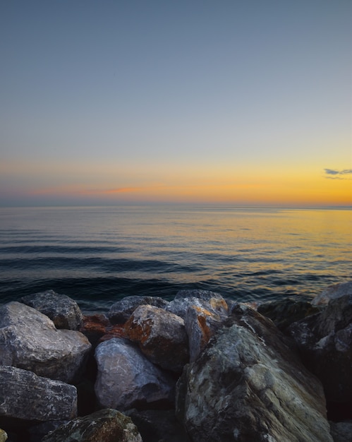 hermosa puesta de sol sobre el mar con marco de piedras de colores