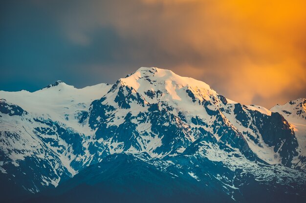 Hermosa puesta de sol sobre el pico de la montaña nevada. Escena del paisaje de la naturaleza. Antecedentes de viaje. Vacaciones, viajes, deporte, recreación. Cordillera del Cáucaso principal, Svaneti, Georgia. Filtro de tono retro