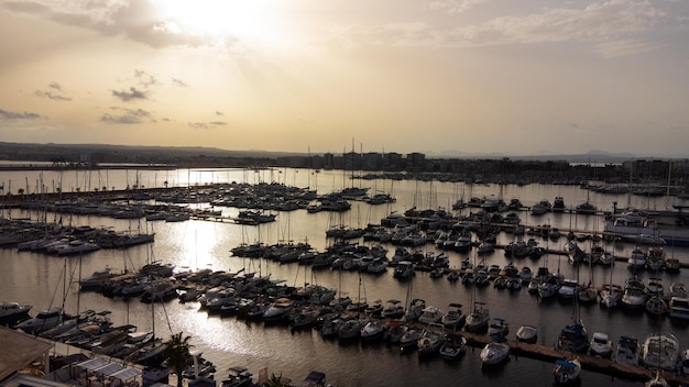 Hermosa puesta de sol sobre el puerto con yates y la ciudad de Torrevieja