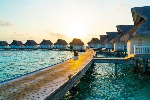 Foto hermosa puesta de sol tropical sobre la isla de maldivas con bungalow de agua en hotel resort