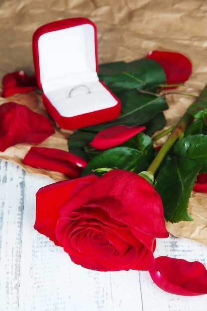 Hermosa rosa roja con anillo en primer plano de la mesa de madera