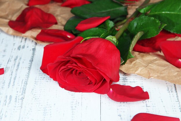 Hermosa rosa roja en primer plano de la mesa de madera