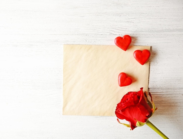 Hermosa rosa con tarjeta de regalo sobre fondo de madera